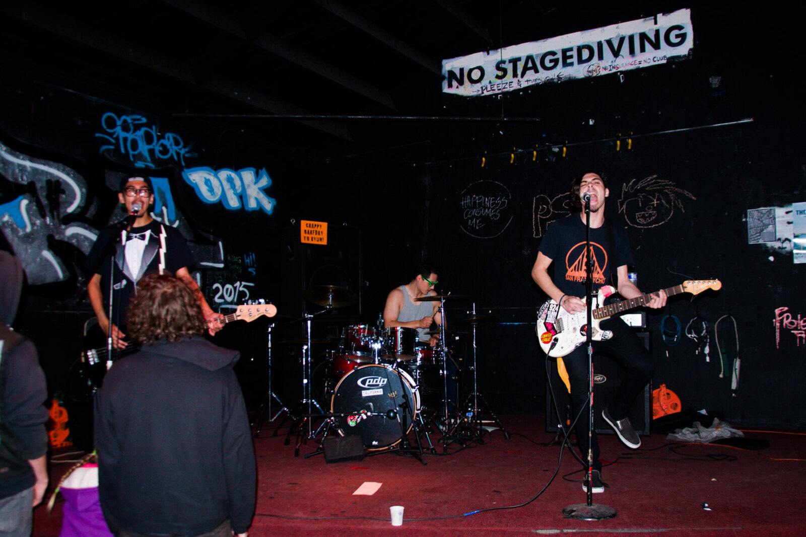 DIY stage and floor area in a small punk venue during a live set